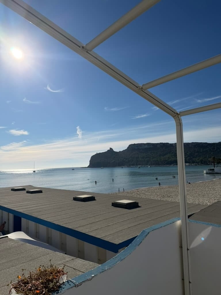 Pergola bianca al sole con il mare e la Sella del Diavolo sullo sfondo